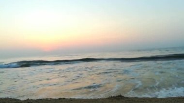 Güneşin doğuşunda balıkçıyla birlikte teknenin silueti Horizon Sunrise sahilinde güzel bir gün doğumu. Okyanus ve altın güneş doğuyor, parlak altın arka plan. Güneşin batışında dramatik bulutlu gökyüzünün olduğu güzel manzara. turuncu 