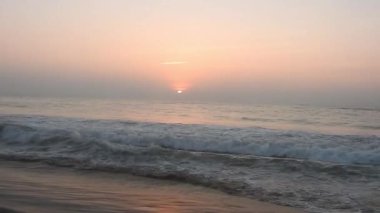Dramatik deniz gündoğumu. Yanan gökyüzü ve parlayan altın dalgalar. Deniz batımı. Turuncu gökyüzünde deniz dalgaları ve arka planda güneş ışığı deniz suyu yüzeyinde parlıyor. Hiç kimse yok, tatil için güzel deniz manzarası, tatil, turistik temalar, gün doğumu