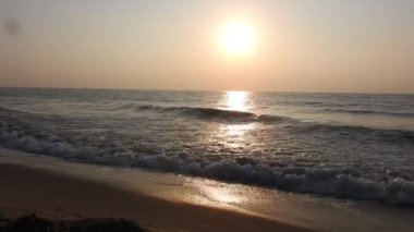 Balıkçı tekneleri eve dönüyor. Hindistan 'ın Odisha kentindeki Puri plajında güneş doğuyor. Doğayla güzel romantik bir manzara. Deniz sahilinde gün doğumunda balıkçı teknesiyle renkli bir gökyüzü. Dramatik deniz gündoğumu. Yanan gökyüzü ve parlayan dalgalar.