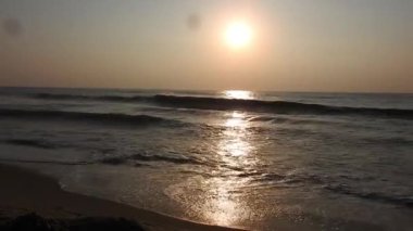Balıkçı tekneleri eve dönüyor. Hindistan 'ın Odisha kentindeki Puri plajında güneş doğuyor. Doğayla güzel romantik bir manzara. Deniz sahilinde gün doğumunda balıkçı teknesiyle renkli bir gökyüzü. Dramatik deniz gündoğumu. Yanan gökyüzü ve parlayan dalgalar.