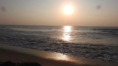 Balıkçı tekneleri eve dönüyor. Hindistan 'ın Odisha kentindeki Puri plajında güneş doğuyor. Doğayla güzel romantik bir manzara. Deniz sahilinde gün doğumunda balıkçı teknesiyle renkli bir gökyüzü. Dramatik deniz gündoğumu. Yanan gökyüzü ve parlayan dalgalar.