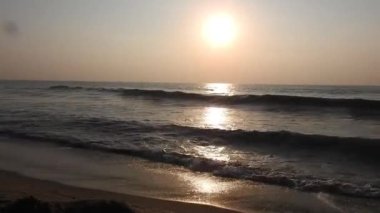 Balıkçı tekneleri eve dönüyor. Hindistan 'ın Odisha kentindeki Puri plajında güneş doğuyor. Doğayla güzel romantik bir manzara. Deniz sahilinde gün doğumunda balıkçı teknesiyle renkli bir gökyüzü. Dramatik deniz gündoğumu. Yanan gökyüzü ve parlayan dalgalar.