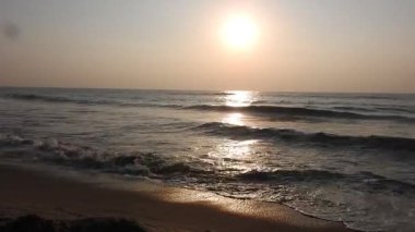 Balıkçı tekneleri eve dönüyor. Hindistan 'ın Odisha kentindeki Puri plajında güneş doğuyor. Doğayla güzel romantik bir manzara. Deniz sahilinde gün doğumunda balıkçı teknesiyle renkli bir gökyüzü. Dramatik deniz gündoğumu. Yanan gökyüzü ve parlayan dalgalar.