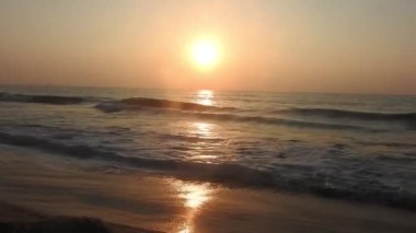 Dramatik deniz gündoğumu. Yanan gökyüzü ve parlayan altın dalgalar. Deniz üzerinde güzel bir gün batımı, sahile vuran okyanus dalgaları denizin üzerine vuran güneş. Plaj palmiyeleri adasında inanılmaz kırmızı gün doğumu. Turuncu renkler gündoğumu ve dalgalar. Doğa Gündoğumu 