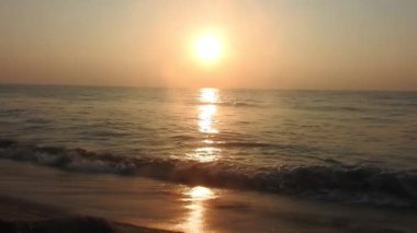 Sabahın erken saatlerinde deniz kıyısında, mavi dalgalar akıyor. Renkli kış gündoğumu. Soğuk fırtınalı dalgalar ve Baltık Denizi üzerindeki bulutlar, yere vuran altın deniz dalgaları. Manzara okyanus güzel manzara deniz üzerinde gün batımı, sahilde okyanus dalgaları