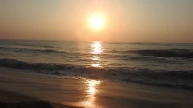 Sabahın erken saatlerinde deniz kıyısında, mavi dalgalar akıyor. Renkli kış gündoğumu. Soğuk fırtınalı dalgalar ve Baltık Denizi üzerindeki bulutlar, yere vuran altın deniz dalgaları. Manzara okyanus güzel manzara deniz üzerinde gün batımı, sahilde okyanus dalgaları