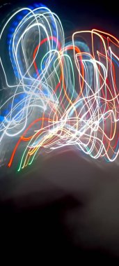 Soy 'da ışık yolları. Sanat eseri. Bir soyda uzun pozlama fotoğrafı. Mavi ve kırmızı ışıkta fotoğraf, uzun pozlu peri mavisi ve kırmızı ışıklar kıvrımlar ve dalgalar siyah arkaplanda. Uzun pozlu ışık resimli fotoğraf. Abs