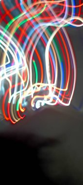 Soy 'da ışık yolları. Sanat eseri. Bir soyda uzun pozlama fotoğrafı. Mavi ve kırmızı ışıkta fotoğraf, uzun pozlu peri mavisi ve kırmızı ışıklar kıvrımlar ve dalgalar siyah arkaplanda. Uzun pozlu ışık resimli fotoğraf. Abs