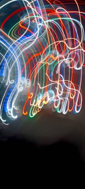 Soy 'da ışık yolları. Sanat eseri. Bir soyda uzun pozlama fotoğrafı. Mavi ve kırmızı ışıkta fotoğraf, uzun pozlu peri mavisi ve kırmızı ışıklar kıvrımlar ve dalgalar siyah arkaplanda. Uzun pozlu ışık resimli fotoğraf. Abs