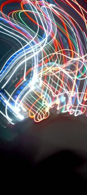 Soy 'da ışık yolları. Sanat eseri. Bir soyda uzun pozlama fotoğrafı. Mavi ve kırmızı ışıkta fotoğraf, uzun pozlu peri mavisi ve kırmızı ışıklar kıvrımlar ve dalgalar siyah arkaplanda. Uzun pozlu ışık resimli fotoğraf. Abs