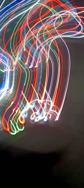 Light trails in Lineage. Art image. Long exposure photo taken in a Lineage. Blue and red light painting photography, long exposure fairy blue and red lights curves and waves against a black background. Long exposure light painting photography. Abs