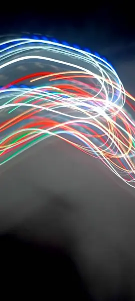 Light trails in Lineage. Art image. Long exposure photo taken in a Lineage. Blue and red light painting photography, long exposure fairy blue and red lights curves and waves against a black background. Long exposure light painting photography. Abs