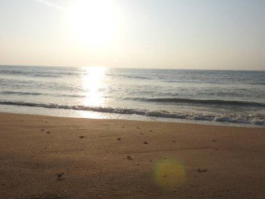 Deniz günbatımının manzarası, okyanusun doğuşu, denizde gün batımı, tropik günbatımı. Okyanusta güzel, kırmızı ve sarı gün batımı kumlu sahil, güneş ışığı ve dalgaları. Renkli ve dramatik Günbatımı Gökyüzü Okyanusu Arkaplanı. Günbatımı Okyanus Dalgası 