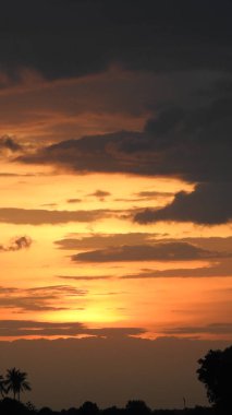 Gölde gün batımında insanların, ağaçların ve teknelerin silueti gün batımında bir arabanın üzerinde dans eden çocukların güzel silueti altın gökyüzü ve siluetli ağaçlar. Çocukların gölgesi parkta birlikte duruyor. Gün batımı gökyüzü ve ağaçlar manzarası.