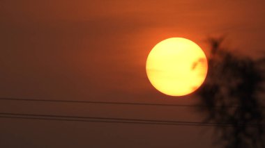 Gölde gün batımında insanların, ağaçların ve teknelerin silueti gün batımında bir arabanın üzerinde dans eden çocukların güzel silueti altın gökyüzü ve siluetli ağaçlar. Çocukların gölgesi parkta birlikte duruyor. Gün batımı gökyüzü ve ağaçlar manzarası.
