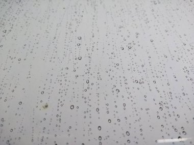 Bulanık bir zemini olan, cam üzerine yağmur damlası damlacıkları doğal arkaplan için desenli. Yağmurdan sonra su damlaları olan cam manzarası. Cama yağmur damlaları, yağmur damlaları. Pencere camına büyük yağmur damlaları. Yağmur suyu. 