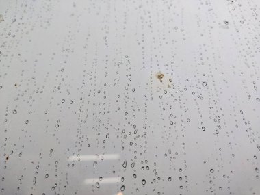 Bulanık bir zemini olan, cam üzerine yağmur damlası damlacıkları doğal arkaplan için desenli. Yağmurdan sonra su damlaları olan cam manzarası. Cama yağmur damlaları, yağmur damlaları. Pencere camına büyük yağmur damlaları. Yağmur suyu. 