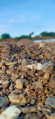 Temiz tatlı suyla nehir yatağındaki kayalar. Deniz suyunda deniz taşları. Suyun altındaki çakıl taşları. Yukarıdan bak. Denizcilik geçmişi. Temiz deniz suyu. Şeffaf deniz. Arka plan gri gri çakıl taşlarından oluşan büyük çakıl taşlarından oluşur. Çakıl taşı 