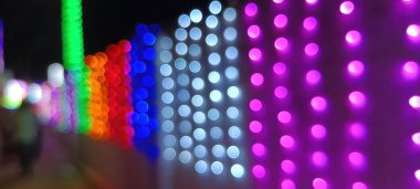 Ampullerin ışığına odaklanıyor. Soyut sahte arka plan, bulanık şehir ışıkları. Parlayan pırıltılı parlak arkaplanlı bulanık bir Noel arkaplanı. Bokeh odaklı soyut arkaplan bulanık renkli bokeh ışık arkaplanı renklendirici 