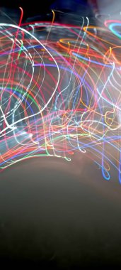 Koyu arkaplanda renkli ışık bokeh. Ampullerin ışığına odaklanıyor. Soyut sahte arka plan, bulanık şehir ışıkları. Parlayan pırıltılı parlak arkaplanlı bulanık bir Noel arkaplanı. Bokeh odaklı soyut arkaplan. Işıklar