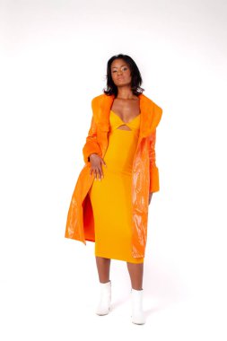 Tüm vücut kendine güvenen, modaya uygun giyinen, kalçaya dokunan ve beyaz arka planda kameraya bakan etnik kadın modeli.