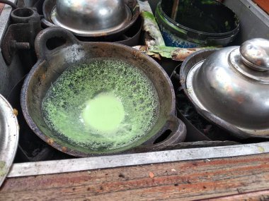 Maymun Pandan Keki ya da Kue Maymun Pandan, kömür ocağında geleneksel bir sobanın üzerinde, toprak kapında pişiriliyor..