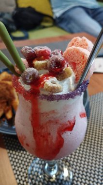 Manzarayı kapat. Lezzetli çilekli milkshake. Kurabiye, fındık ve sopa çayıyla servis ediliyor.