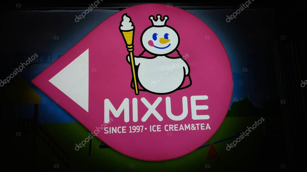 Bandung, Indonesia - January 2, 2022: Chinese ice cream and tea companies are now popular in Indonesia and many new Mixue outlets are opening. Signboard on black background color