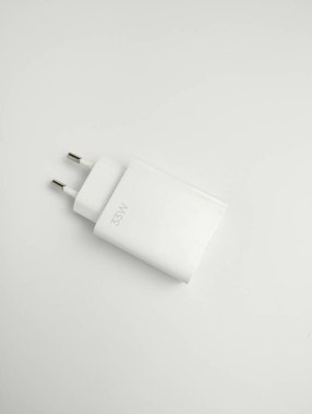 Beyaz telefon şarj aleti kafası beyaz arka planda izole edilmiş. USB şarj edici