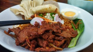 Kızarmış Udon Eriştesi. Dilimlenmiş sığır eti, sebze, yumurta ve hamur köftesi.