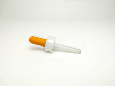 Beyaz arkaplanda portakal damlası pipeti izole edildi