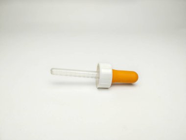 Beyaz arkaplanda portakal damlası pipeti izole edildi