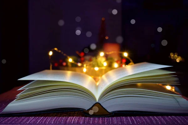 Bir masanın arka planında bir sürü ışık ve ampul olan kitap ve sayfaları aç