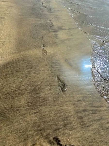 footsteps on the beach sand waves