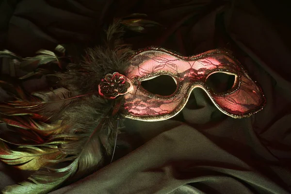 stock image venetian mask, theater mask on black background with red shine