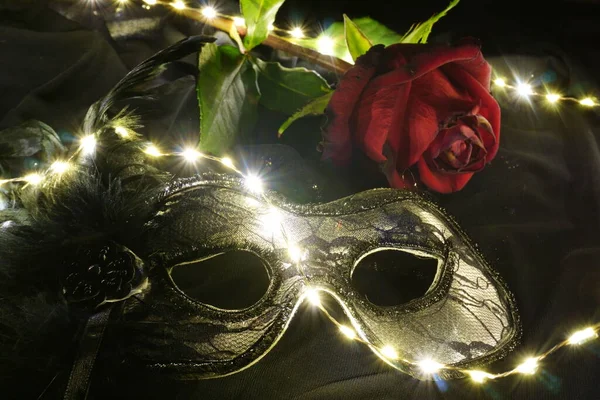 Kırmızı gül ve ışık saçan Venedik karnaval maskesi