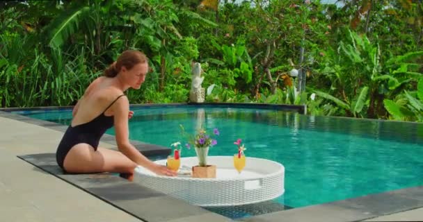 Woman Relaxing Pool Breakfast Glass Orange Cocktail Rear View Lonely — Stock Video