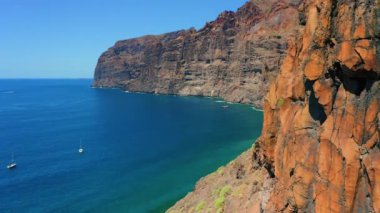 İspanyol Kanarya Adaları 'nın Tenerife' sindeki Atlantik Okyanusu 'nun çarpıcı kayalık kayalık kayalık kıyıları. Bulutsuz gökyüzüne karşı berrak mavi deniz suları. Hava sineması uçuşu. Kimse..