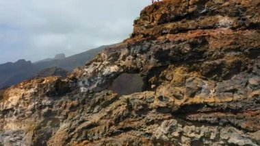 İspanya 'nın Kanarya Adaları, Tenerife' deki Los Gigantes El agujero sahilindeki kayalık doğal delikte uçan sinematik hava. İnanılmaz bir manzara. Yürüyüş alanı. Büyük volkanik oluşum. Turist