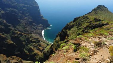 Kayalık kanyonun üzerinde uçmak, büyük uçurumlar, mavi okyanus kıyıları. Güzel, geniş vadi Masca 'yı ortaya çıkar. Tenerife Adası. İspanya. Atlantik kıyı şeridine özel drone görüntüsü. Kimse..