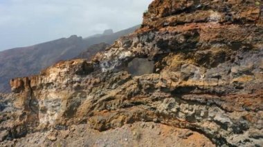 Turistik eğlence, dağ mağarası, uçurumun tepesine giden tehlikeli bir yol. Kaya oluşumunda belirgin bir delik var. El agujero Los Gigantes Tenerife. Hava görüntüsü. Kimse..