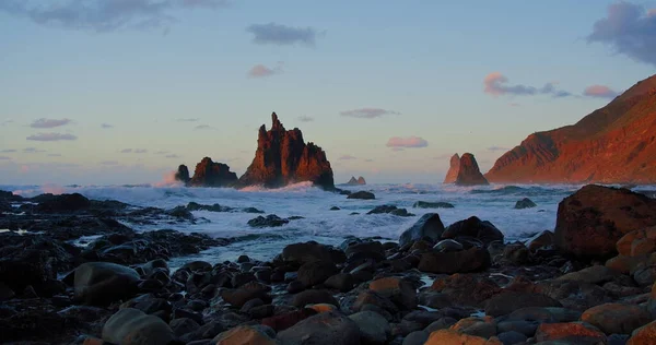 Göz kamaştırıcı muhteşem dalgalar, Tenerife, Kanarya Adaları 'ndaki Benijo Sahili' nde güzel gün batımı ışıkları ve güneş ışınlarıyla yükseliyor. Okyanustaki büyük dalgalar kayalara çarpıyor. Rahat ol. Kimse..