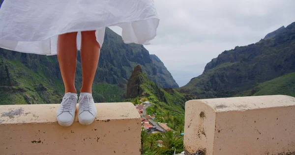 Genç kadın sağlıklı bacaklar, doğal ten rengi. Arka planda dağ yeşili. Masca vadisi güneşli bir günde tropikal doğa manzarası. Güzel bir manzara. İspanya gezisi