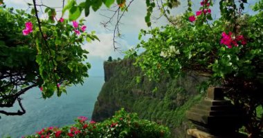 Uluwatu Tapınağı Pura Luhur Hindu 'nun bulunduğu el değmemiş tropik yeşil sahil uçurum ve Bali adasında sonsuz okyanus ufku. Yaz tatili. Bali deniz suyu ve kayalık kıyı şeridi