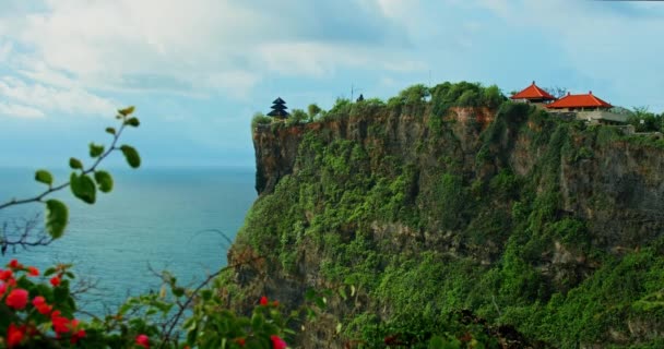 ウルワツ寺院と原始的な熱帯緑のビーチプーラ ルフー ヒンズー教徒は バリ島の巨大な崖の深淵と無限の海の地平線にあります 夏休み バリの海の水と岩の海岸線 ゆっくり — ストック動画