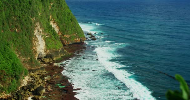 プリーストリー太平洋とバリ島の自然景観 緑豊かなエキゾチックな緑と青い海 絵のように美しい海岸で晴れた日 ウルワツビーチ 静的なビューです スローモーション 海の波が発泡 — ストック動画