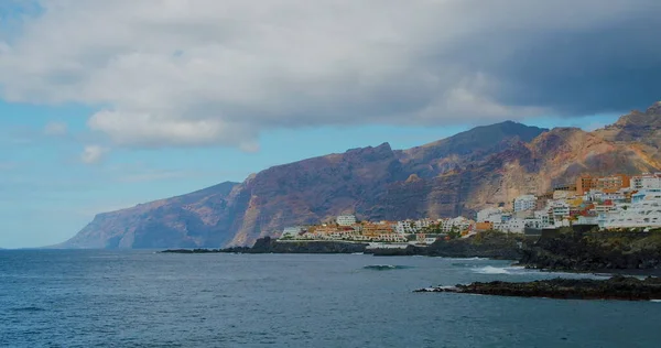 Gün batımı. İspanya, Tenerife 'deki Los Gigantes şehrinin muhteşem manzarası. Şehir manzarası ve deniz kıyısı, Puerto de Santiago 'nun sahil şeridi..