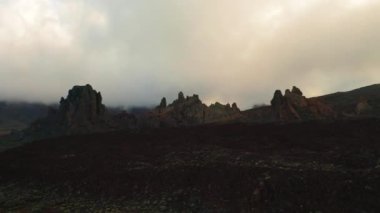 Dağlarda yağışlı hava. Sisli sis uçurumlardan uçuyor. Terk edilmiş tepelerin hava görüntüleri. Gece bulutları. Teide Ulusal Parkı. Drone günbatımı. Doğa manzarası. Kimse..