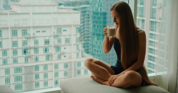 Jovem Mulher Sorridente Bebendo Café Delicioso Perto Janela Com Arranha — Vídeo de Stock