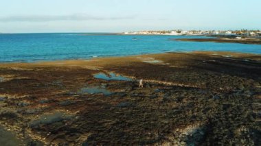 Kanarya adaları, İspanya. Fuerteventura, caddelerin ve binaların güzel manzarası. Tatil köyü. Seyahat bağımlısı. Cennet turistik mekanı. Gün batımı. Corralejo havacılık şehri, liman şehri. Havadan. Kız yürüyüşü